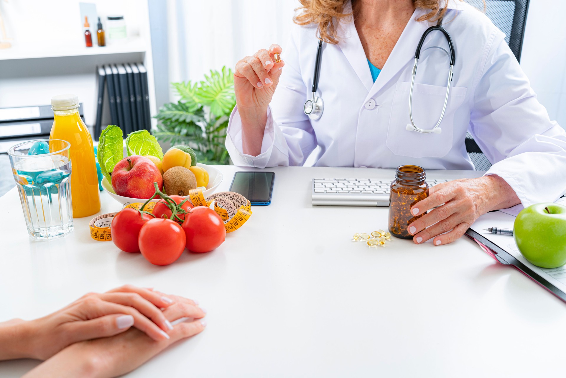Female doctor showing to patient nutritional supplement capsule